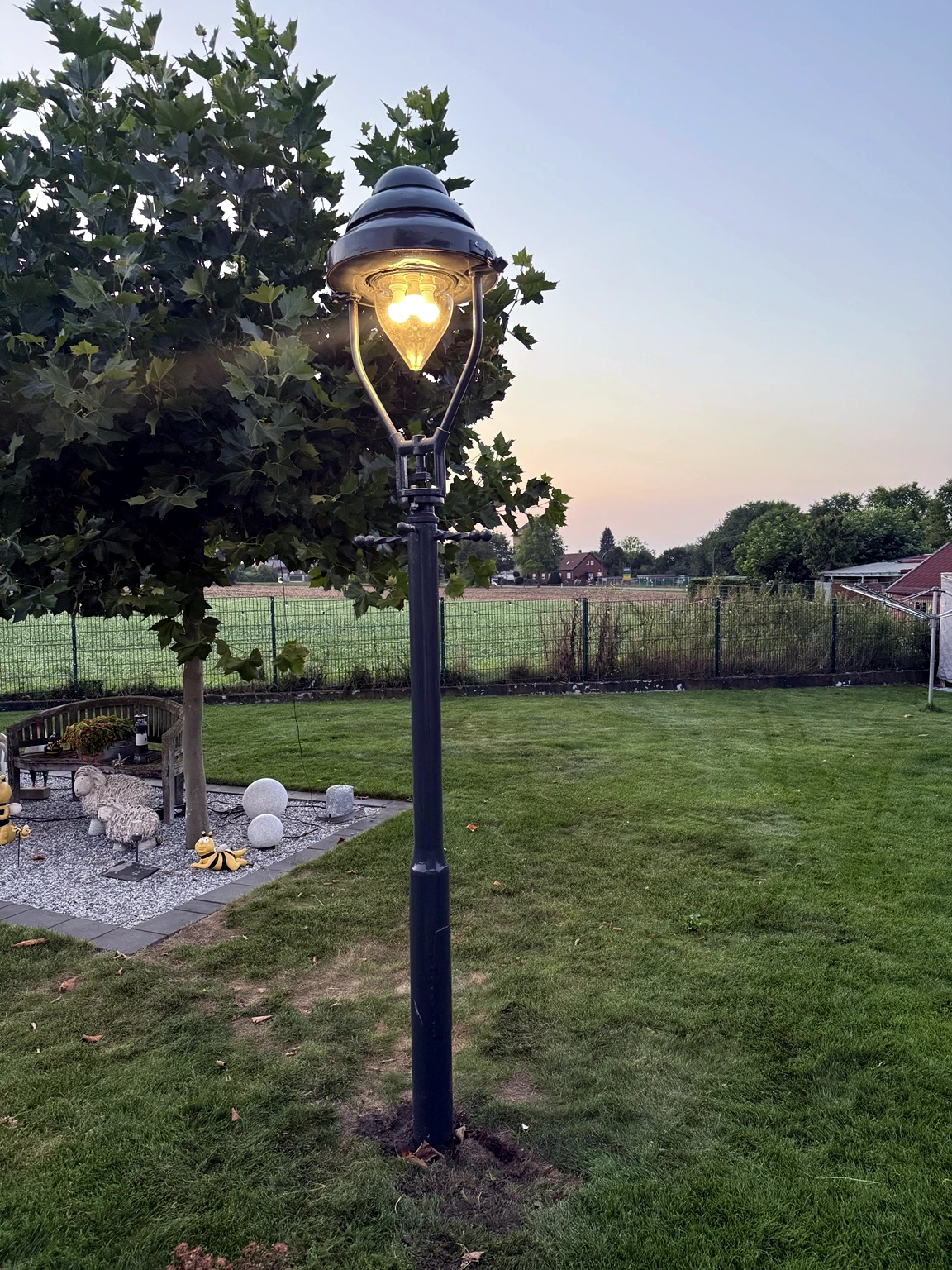 Fertig restaurierte historische Laterne im Garten bei Abendlicht